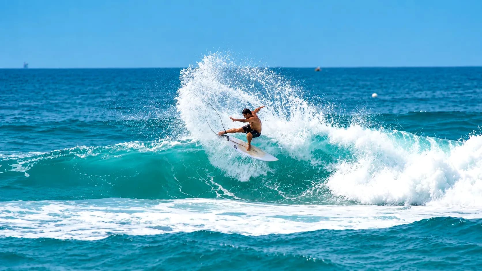 Surfer throwing spray off the lip of a wave