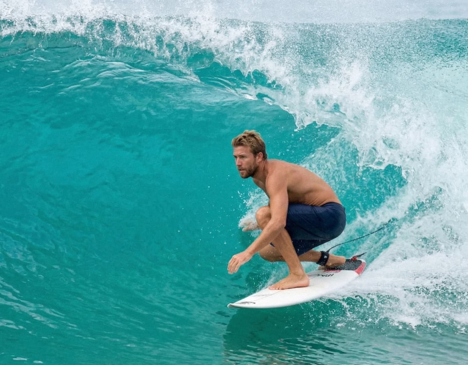 Surfer crouched in a turquoise barrel